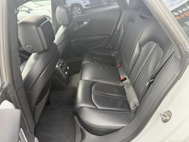 Vue intérieure côté droit des sièges arrière en cuir noir de l'Audi A7 Sportback blanc 2018.