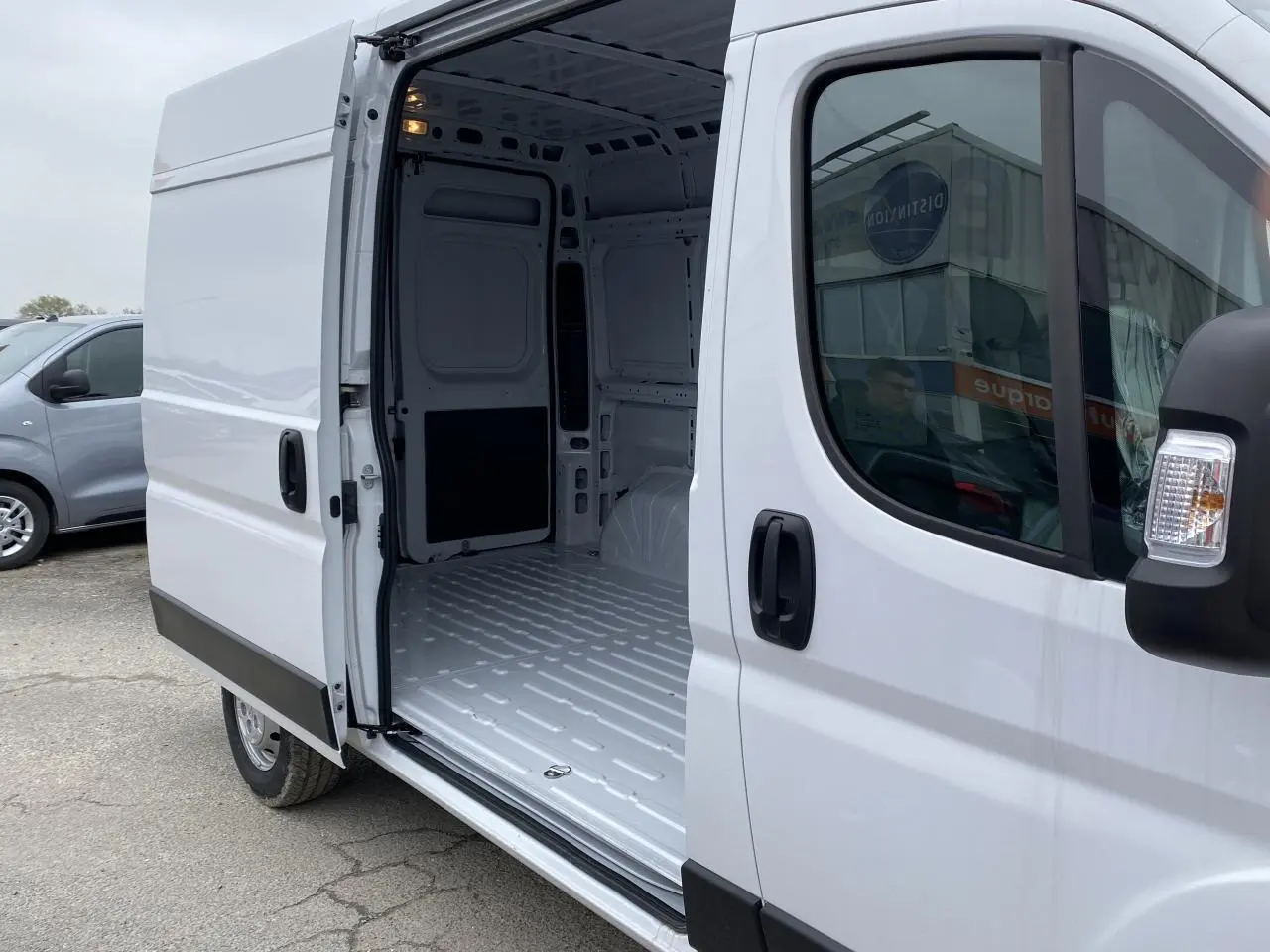 Vue latérale droite d’un Opel Movano Fourgon blanc 2022 avec porte coulissante ouverte montrant l’intérieur vide tôlé.