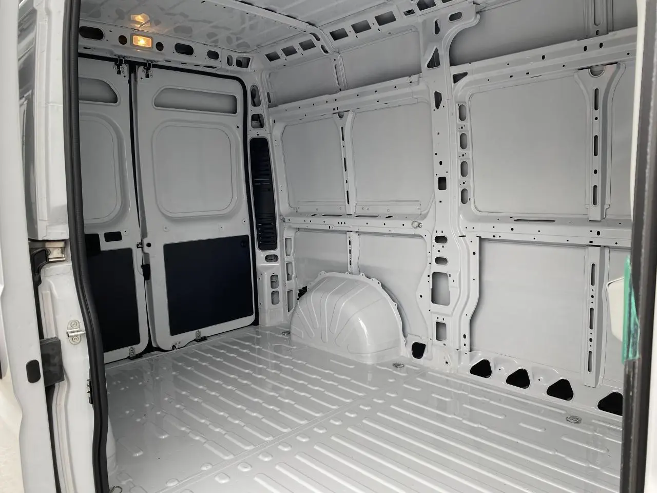 Intérieur blanc du fourgon Opel Movano 2022 vu côté droit, montrant plancher et parois tôlées sans aménagement.