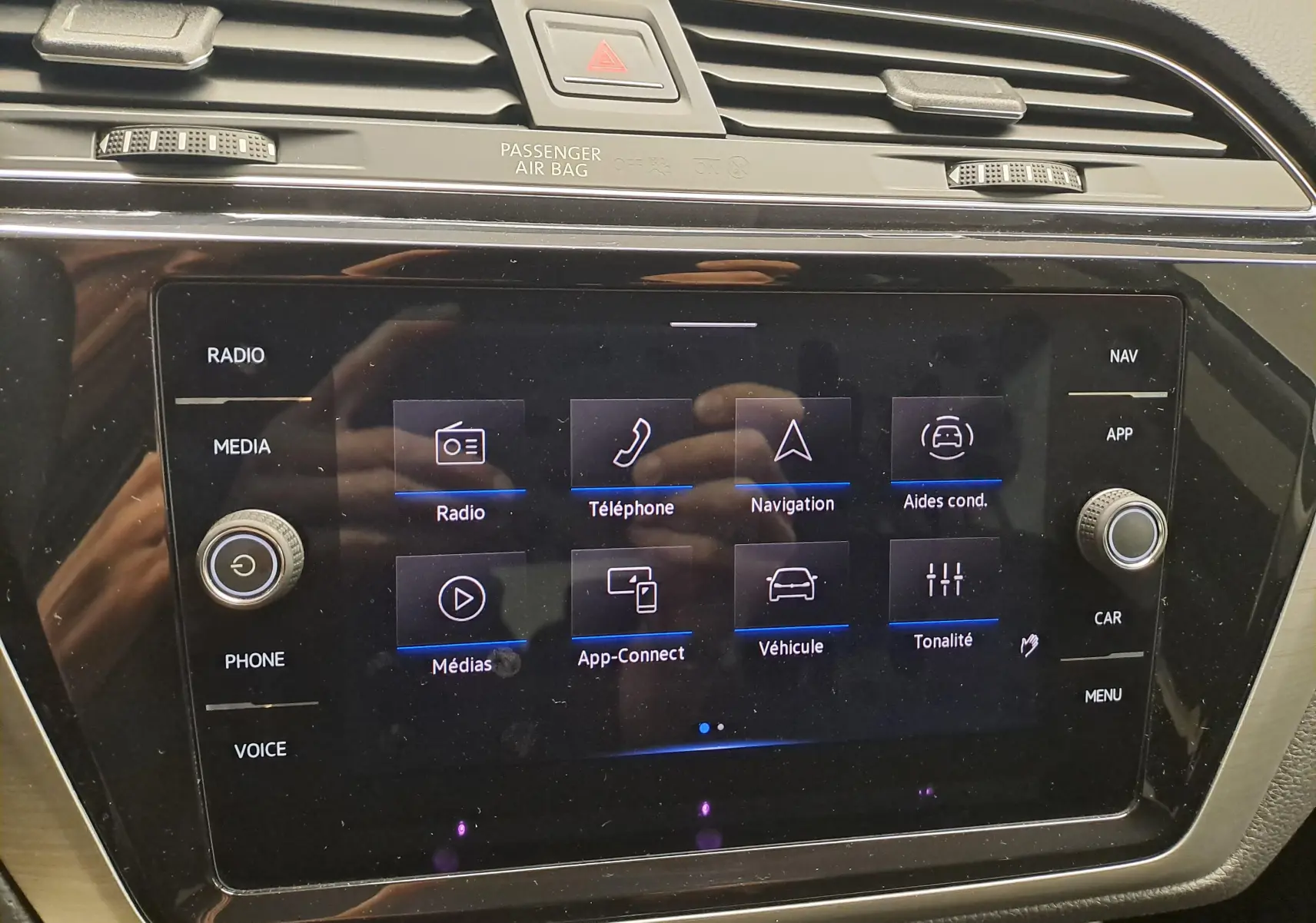 Écran tactile central du Volkswagen Touran 2024 affichant les options radio, téléphone, navigation et aides à la conduite.