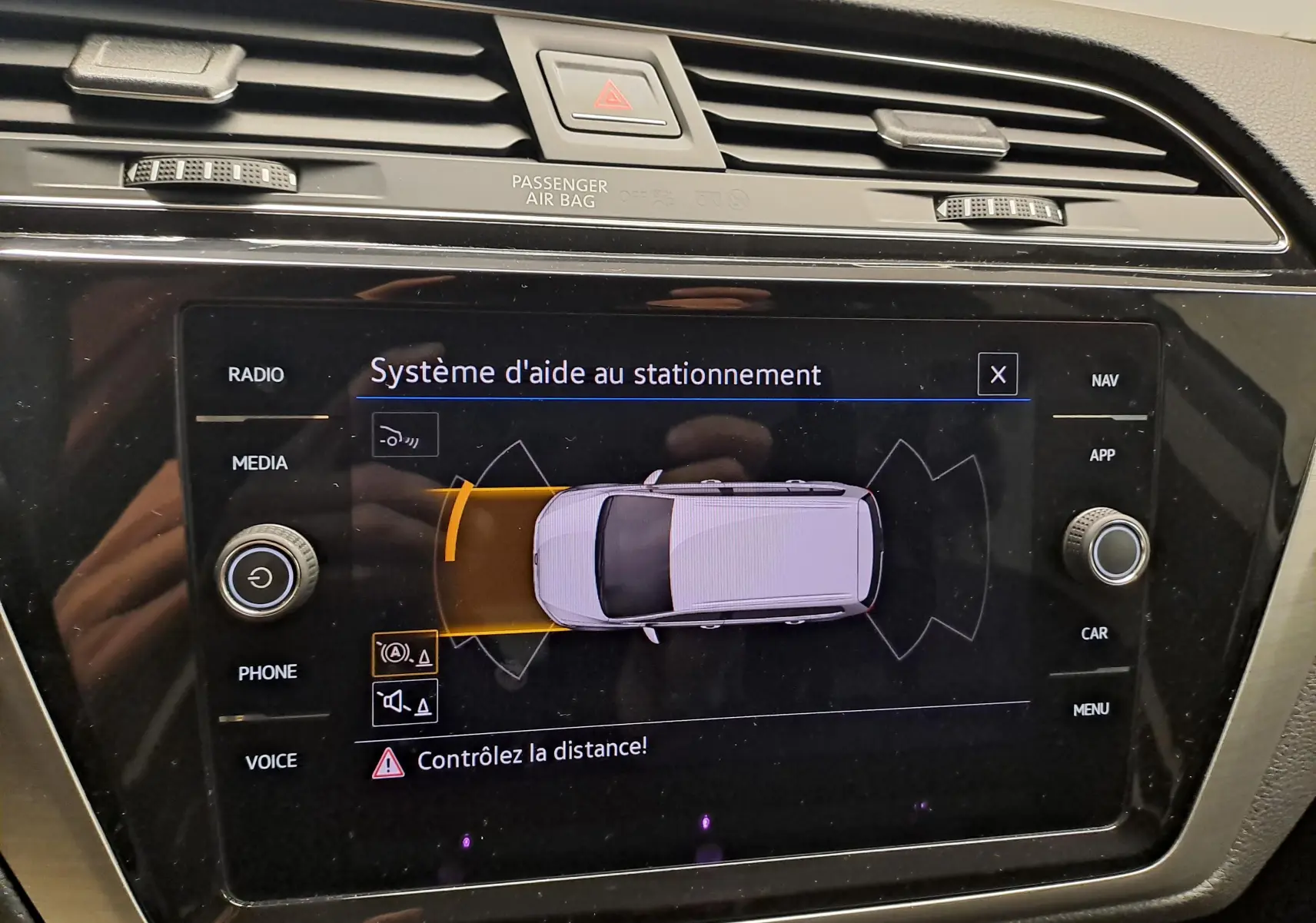 Écran tactile du système d'aide au stationnement dans l'habitacle du Volkswagen Touran 2024, affichage en vue de dessus.