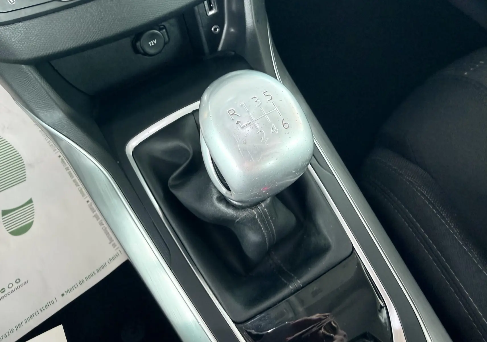 Vue rapprochée du levier de vitesses manuel gris et noir de la Peugeot 308 1.6 BHDI, intérieur tissu noir.