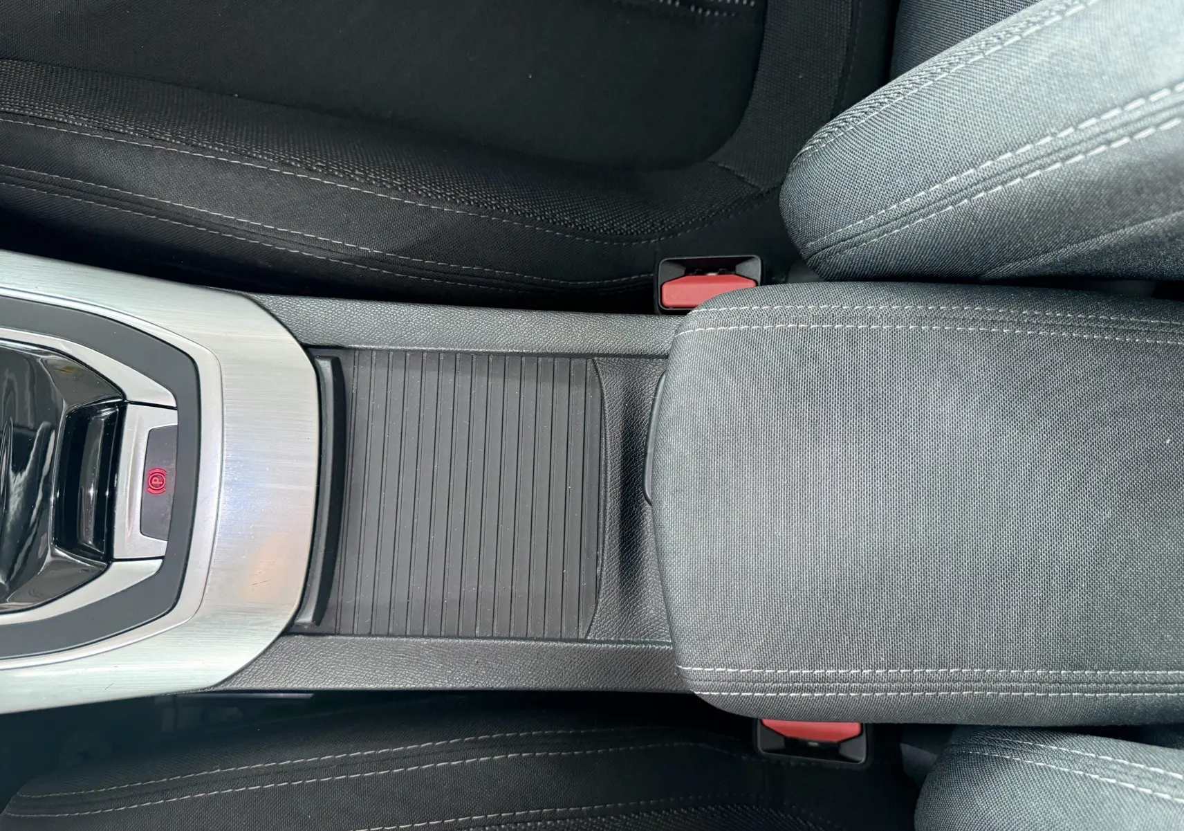 Vue rapprochée de la console centrale et accoudoir en tissu noir de la Peugeot 308 2016, intérieur sobre.