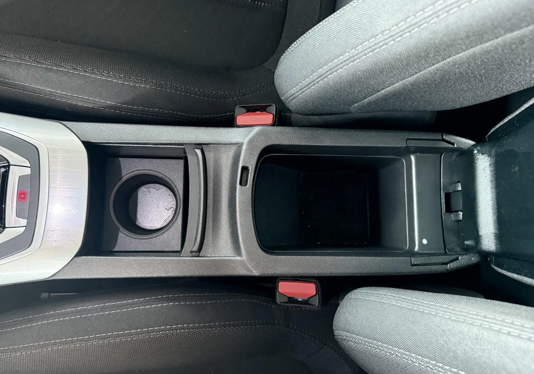 Vue plongeante sur la console centrale noire avec porte-gobelet et accoudoir ouvert de la Peugeot 308 2016.