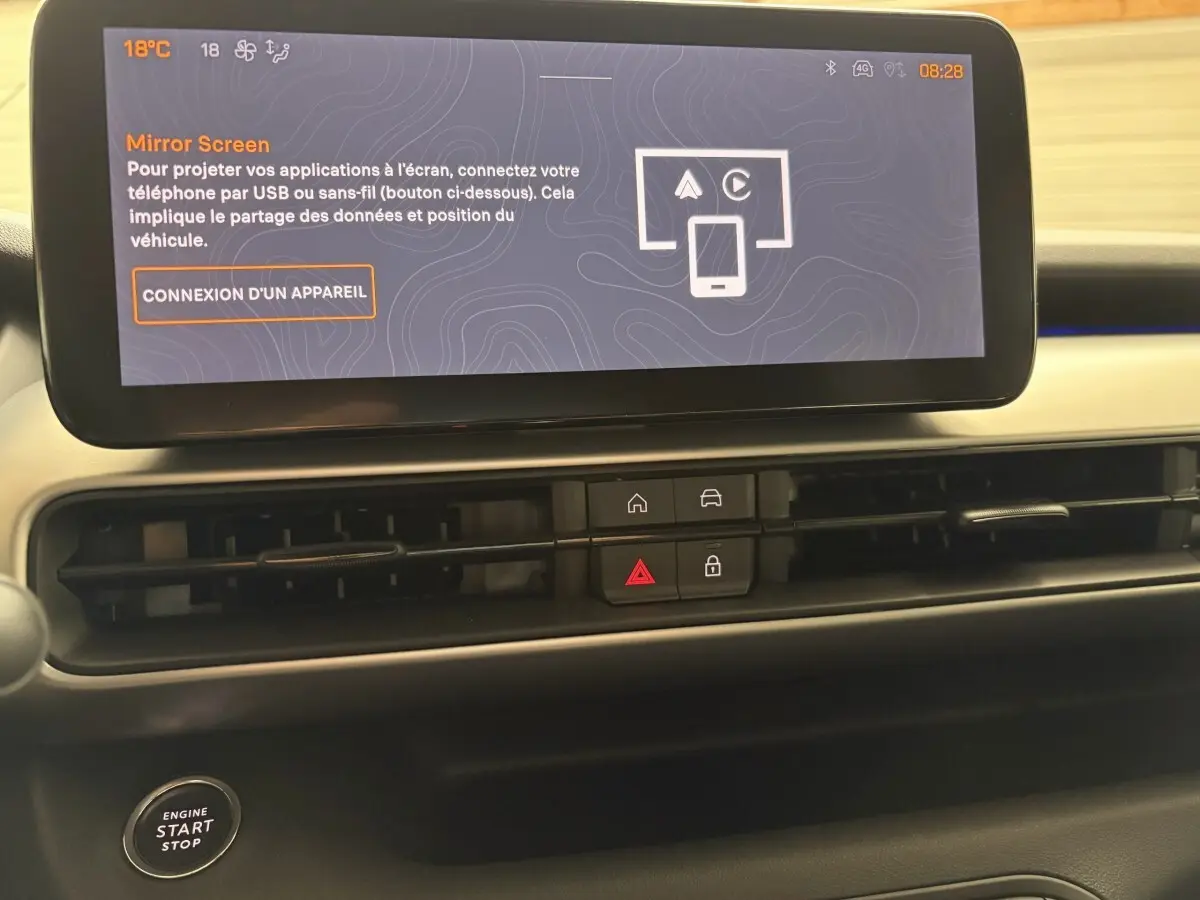 Vue rapprochée du tableau de bord du Jeep Avenger 2025 noir, avec écran tactile central et commandes de climatisation.