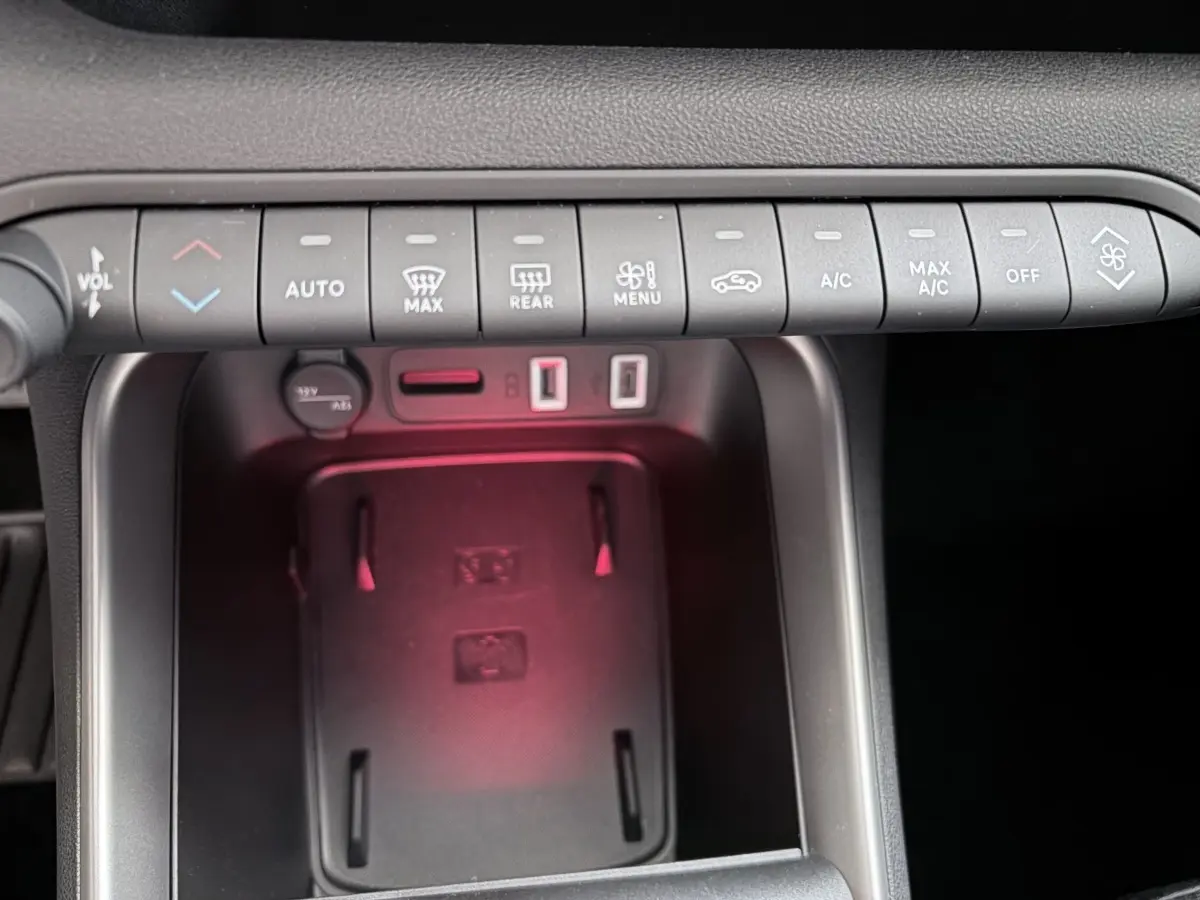 Gros plan sur la console centrale du Jeep Avenger noir, montrant les commandes climatisation et ports USB.