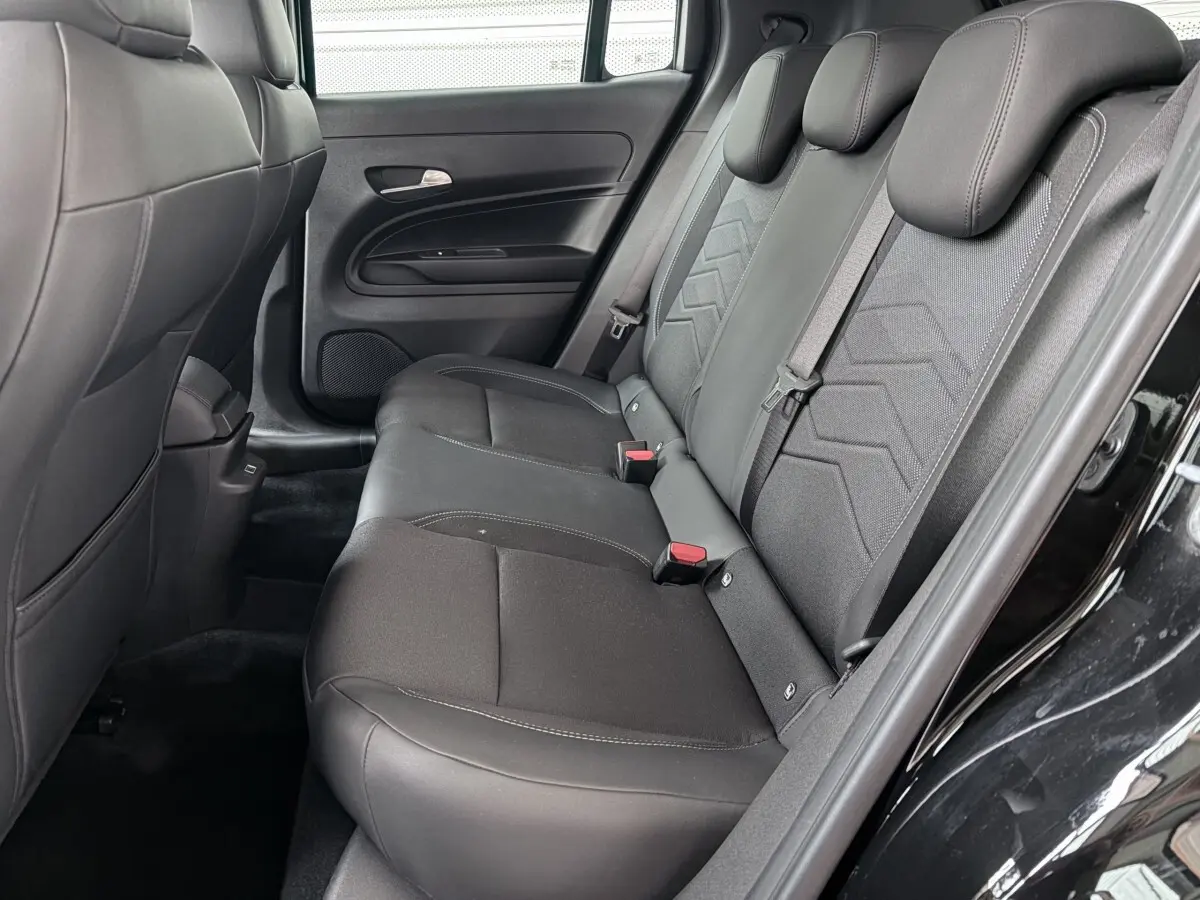 Vue côté droit de la banquette arrière noire du Jeep Avenger 2025 avec ceinture et appuie-têtes intégrés.