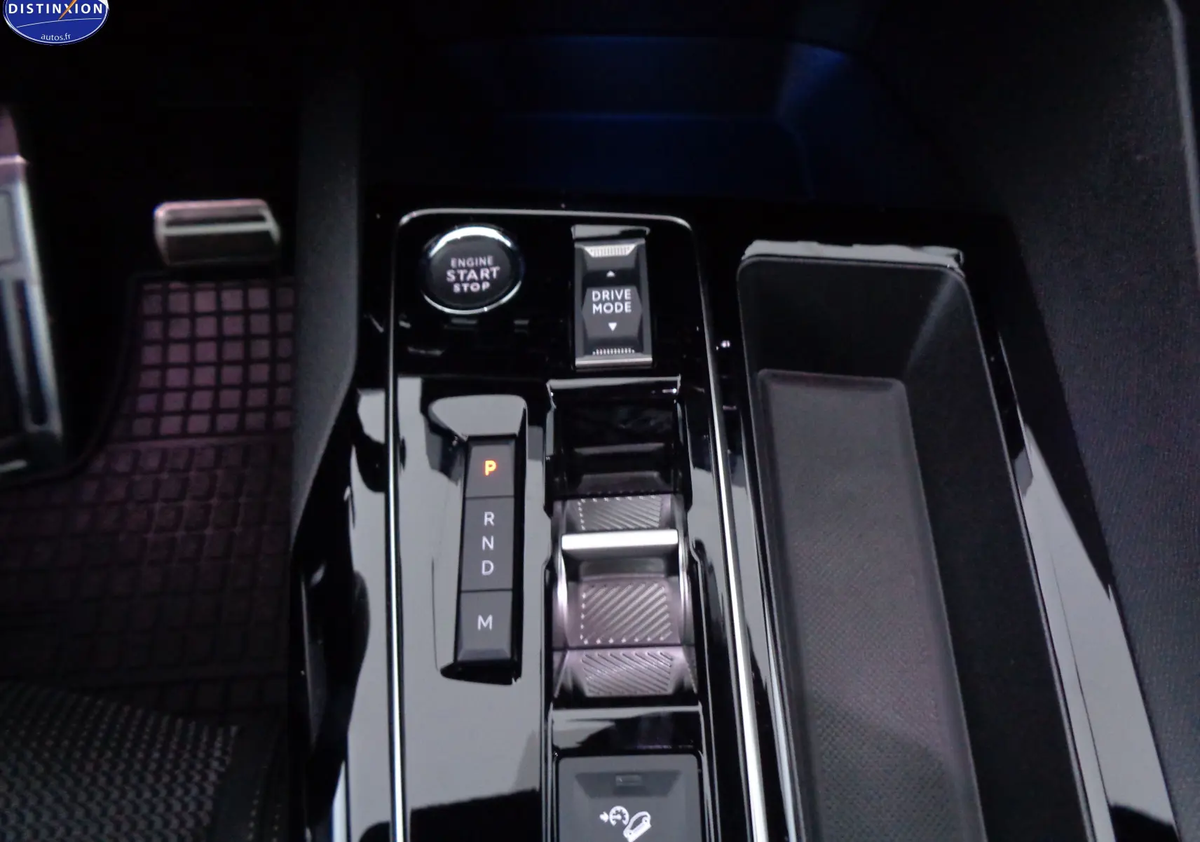 Vue rapprochée de la console centrale noire brillante du Peugeot 3008 gris platinium, avec bouton start et sélecteur de mode de conduite.