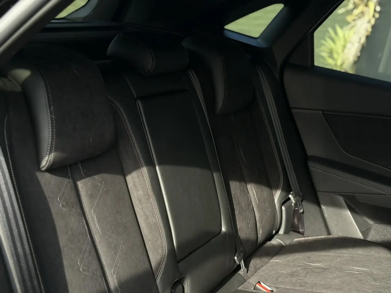 Banquette arrière en Alcantara noir profond avec surpiqûres, vue côté droit du DS7 2025 noir Perla