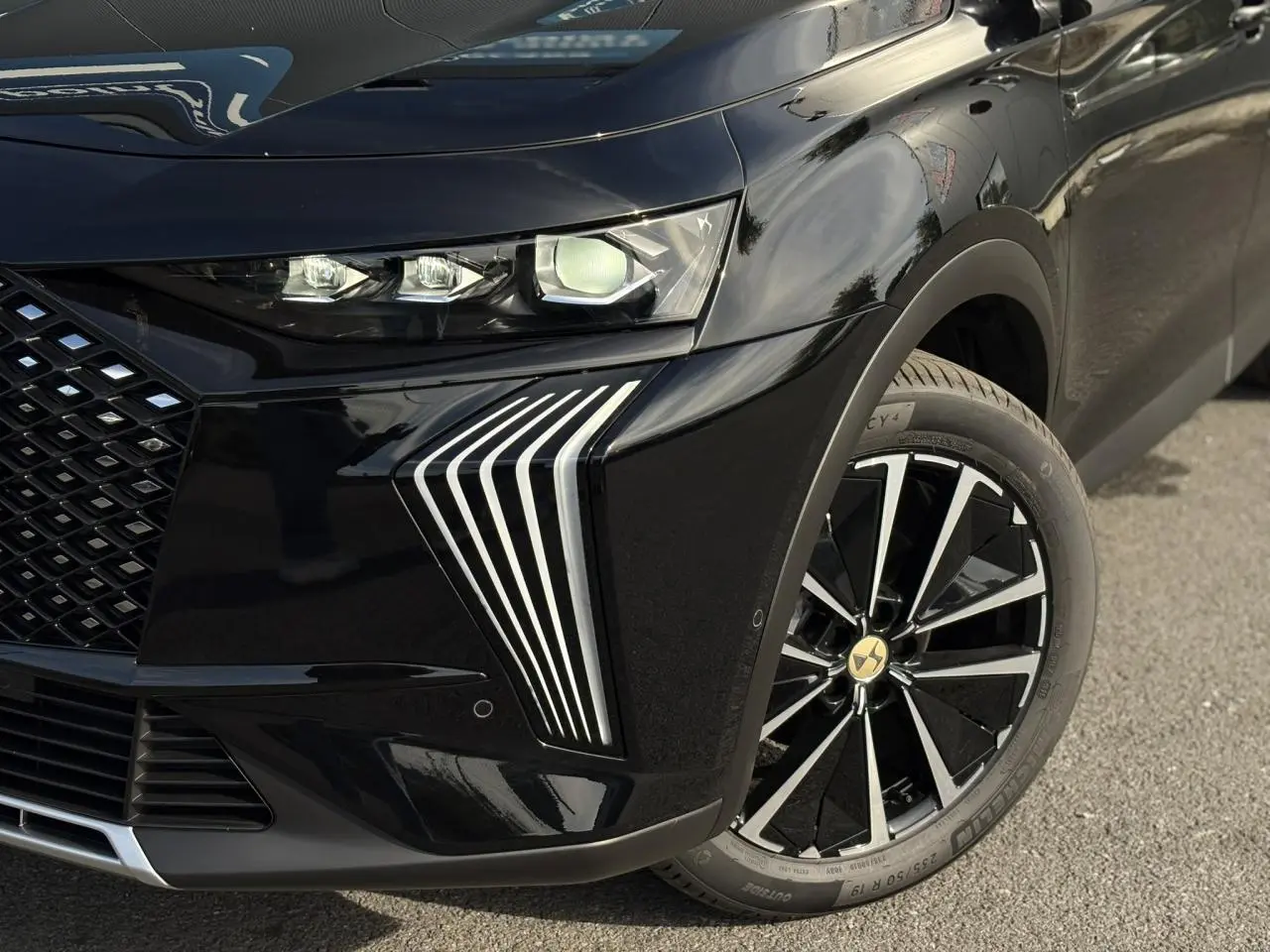 Gros plan sur l'avant droit noir Perla du DS7 2025, mettant en valeur les phares et jantes alliage 19'' Edinburgh.