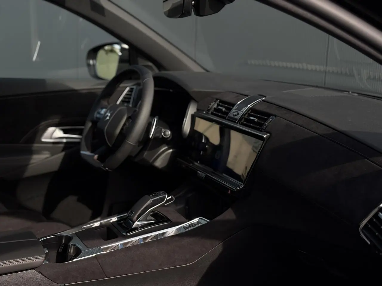 Intérieur noir Alcantara du DS7 2025 vu côté conducteur, avec volant cuir et écran tactile central large.