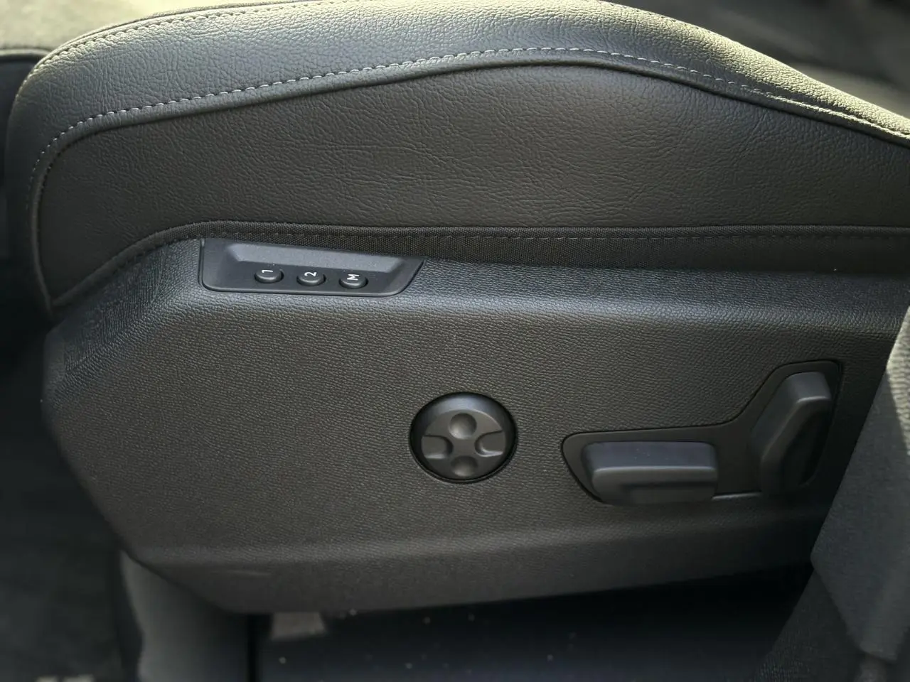Gros plan sur les commandes électriques de réglage lombaire du siège avant en cuir noir du DS7 2025.
