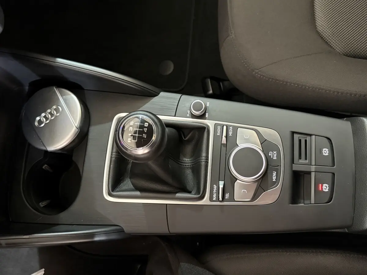 Vue rapprochée du levier de vitesses manuel et de la console centrale noire d’une Audi A3 bleu 2018.