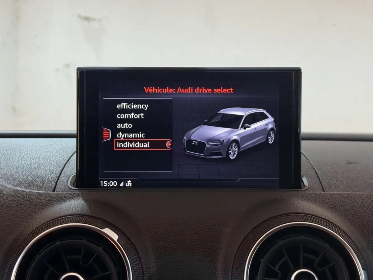 Écran central affichant le menu Audi drive select avec une vue 3D d'une Audi A3 grise en profil avant droit.