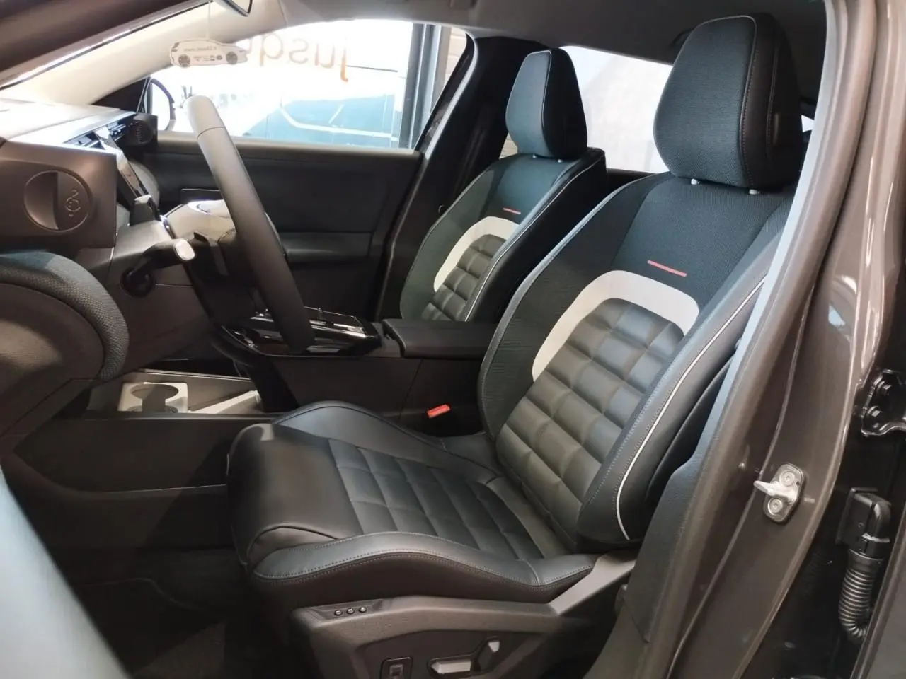 Vue intérieure côté conducteur du Citroën C5 Aircross gris platine, mettant en valeur les sièges avant noirs avec inserts blancs.