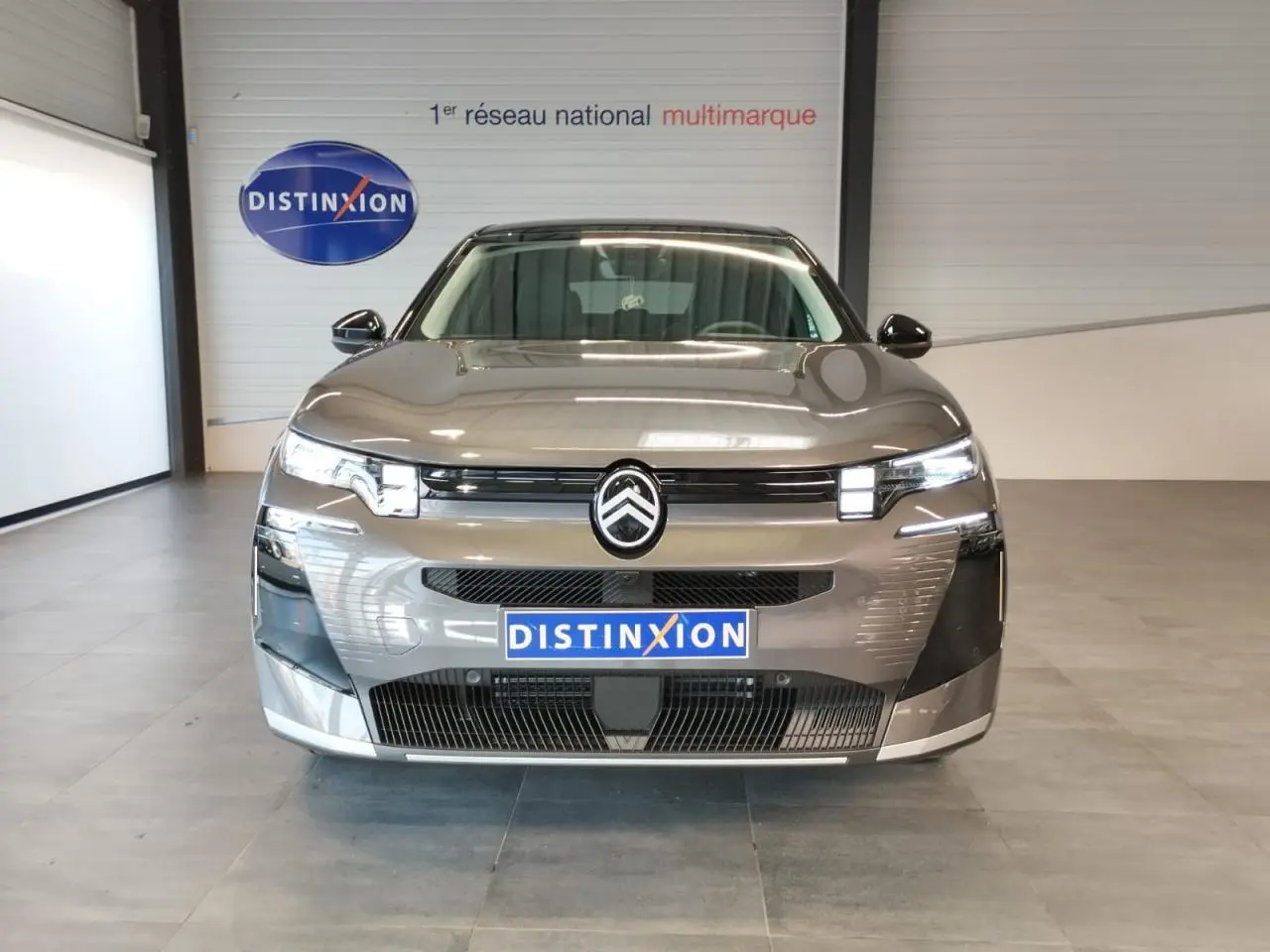 Vue frontale d'un Citroën C5 Aircross gris platine avec calandre noir brillant et feux LED distinctifs.