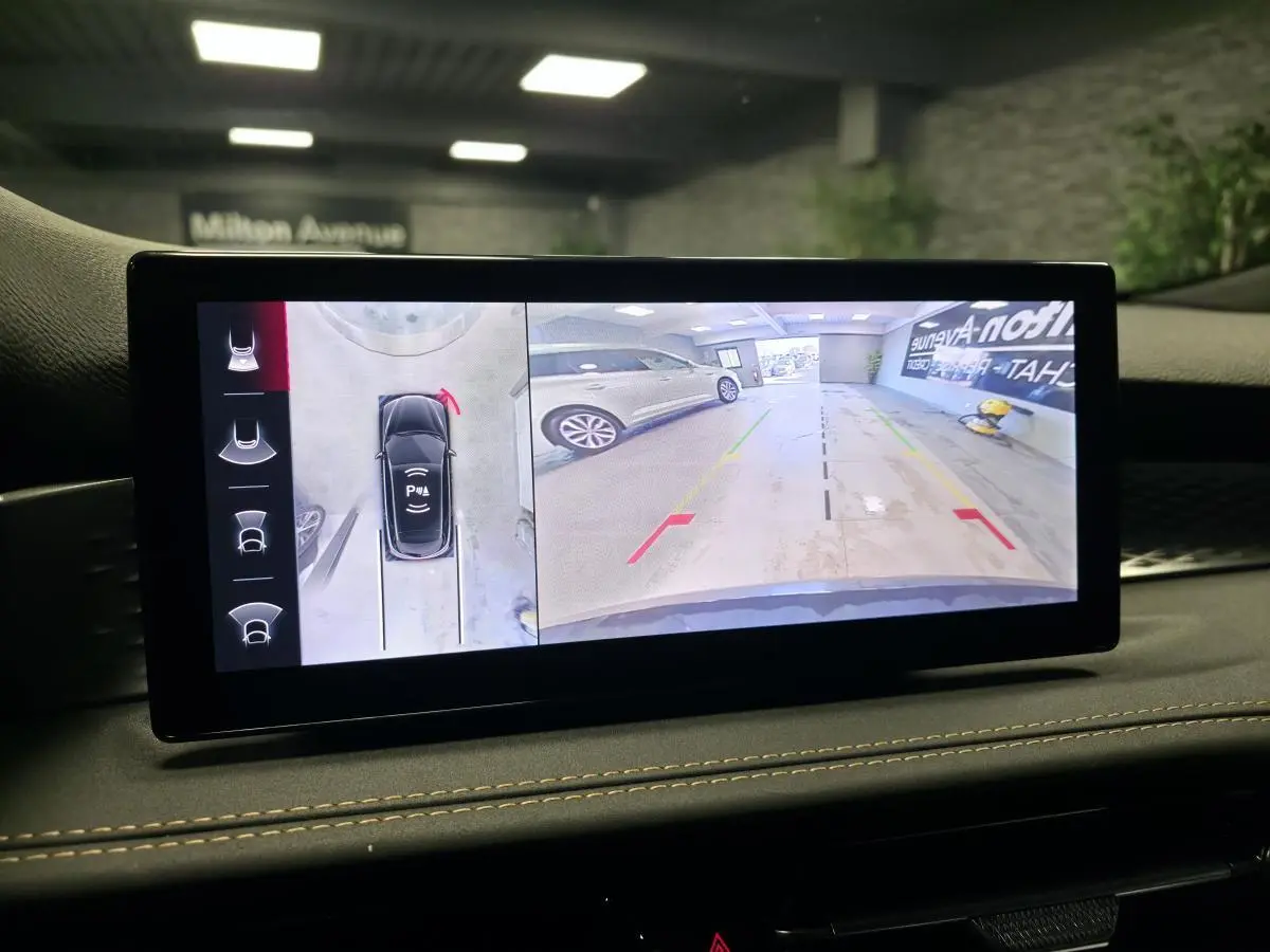 Écran intérieur affichant la caméra 360° de l'Alfa Romeo Tonale Sprint bleu, vue arrière en parking.