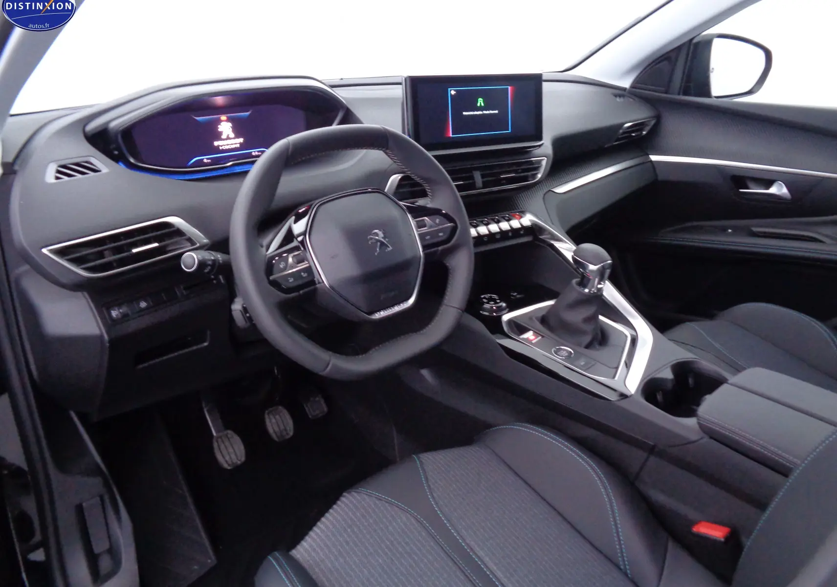 Intérieur avant droit du Peugeot 3008 noir perle métal 2023, volant compact, tableau de bord numérique et levier de vitesse manuel.