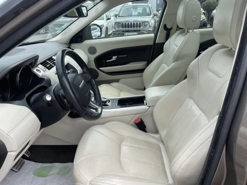 Intérieur clair du Range Rover Evoque marron métal 2017, vue côté conducteur avec sièges cuir beige et tableau de bord moderne.
