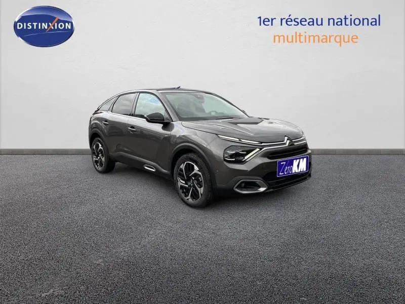 Citroën C4 gris vue 3/4 avant droit, avec jantes alliage et feux LED distinctifs sur fond neutre.