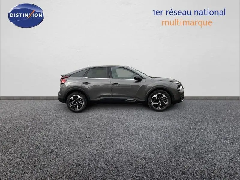 Profil droit d'une Citroën C4 gris 2024 avec jantes alu noires et toit noir contrasté sur fond clair.