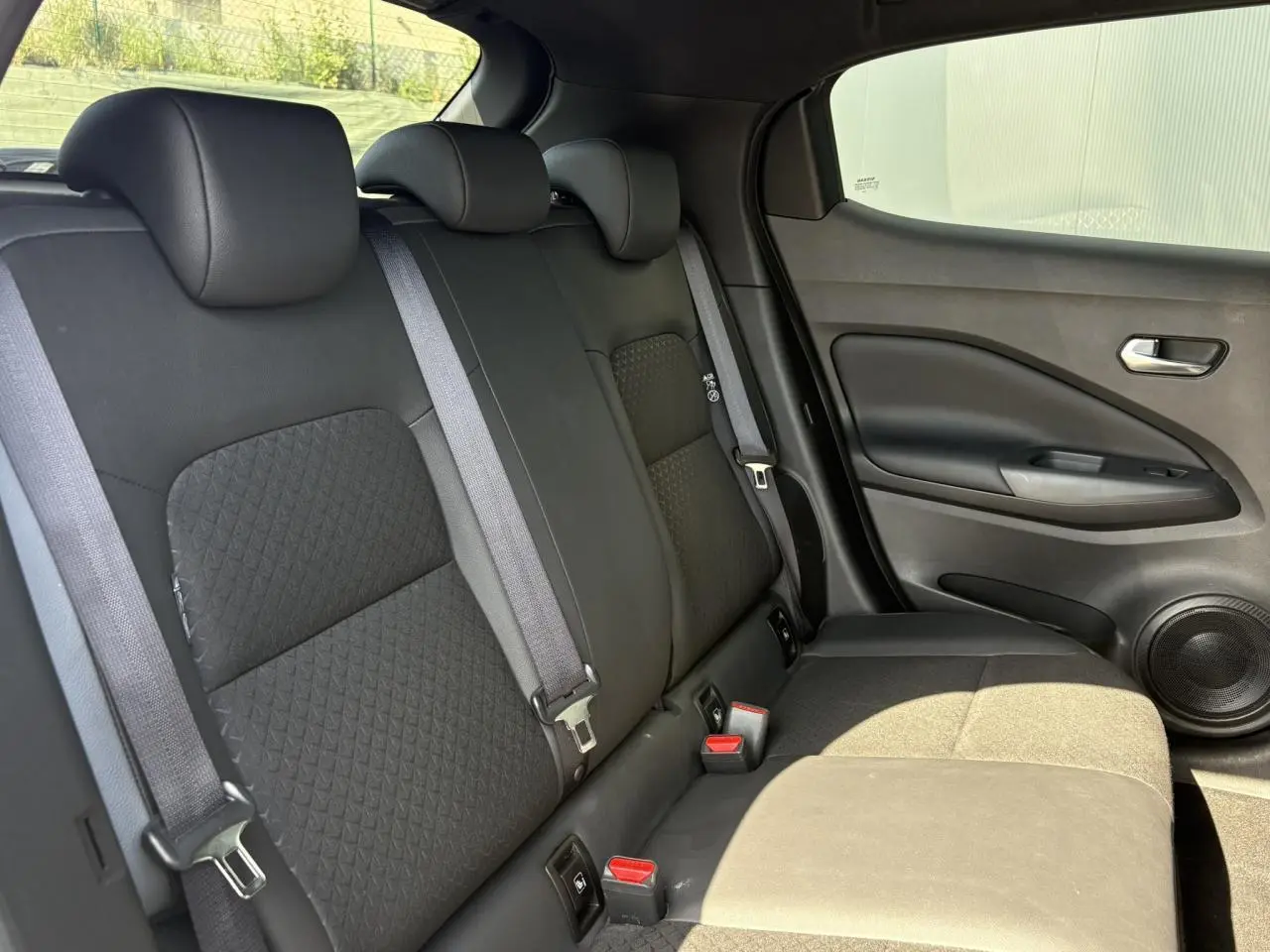Vue latérale droite de la banquette arrière noire en tissu et TEP du Nissan Juke 2024 Gris Dark Metal.