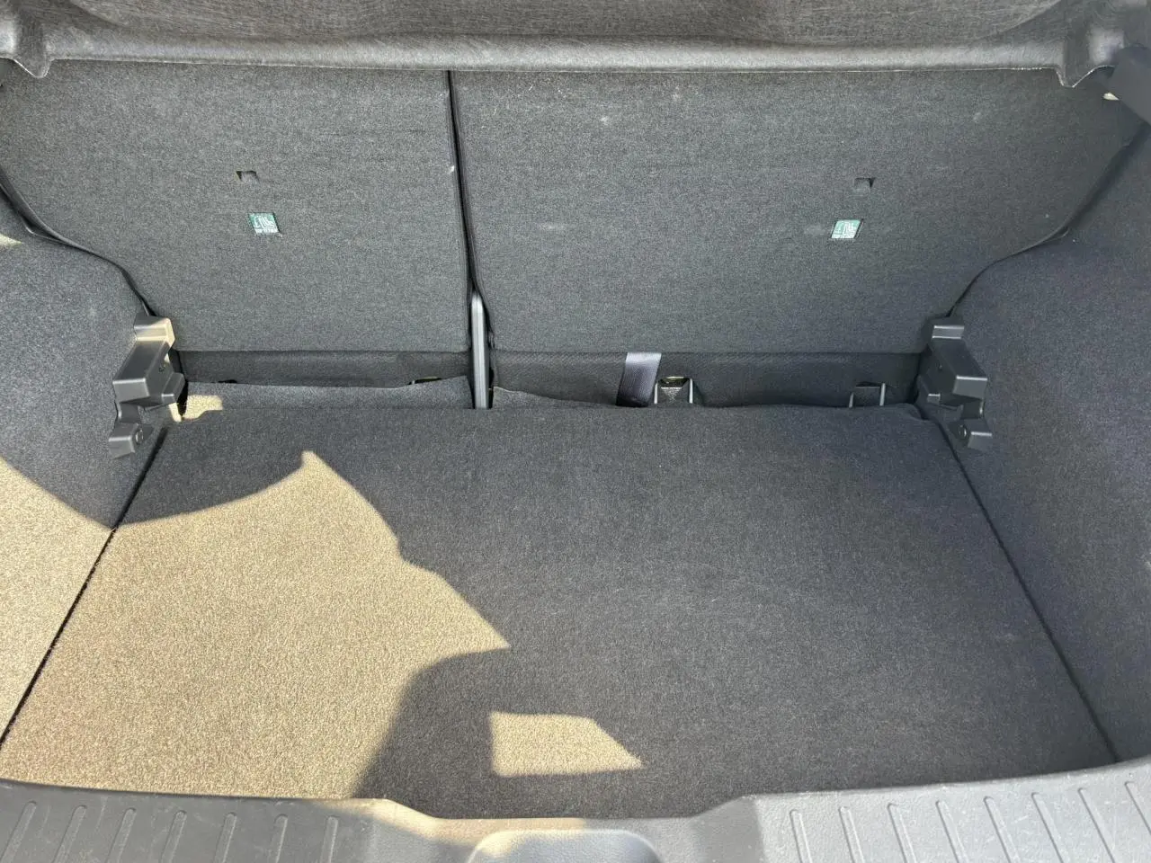 Coffre spacieux du Nissan Juke 2024 gris Dark Metal, vue intérieure arrière avec banquette rabattue.