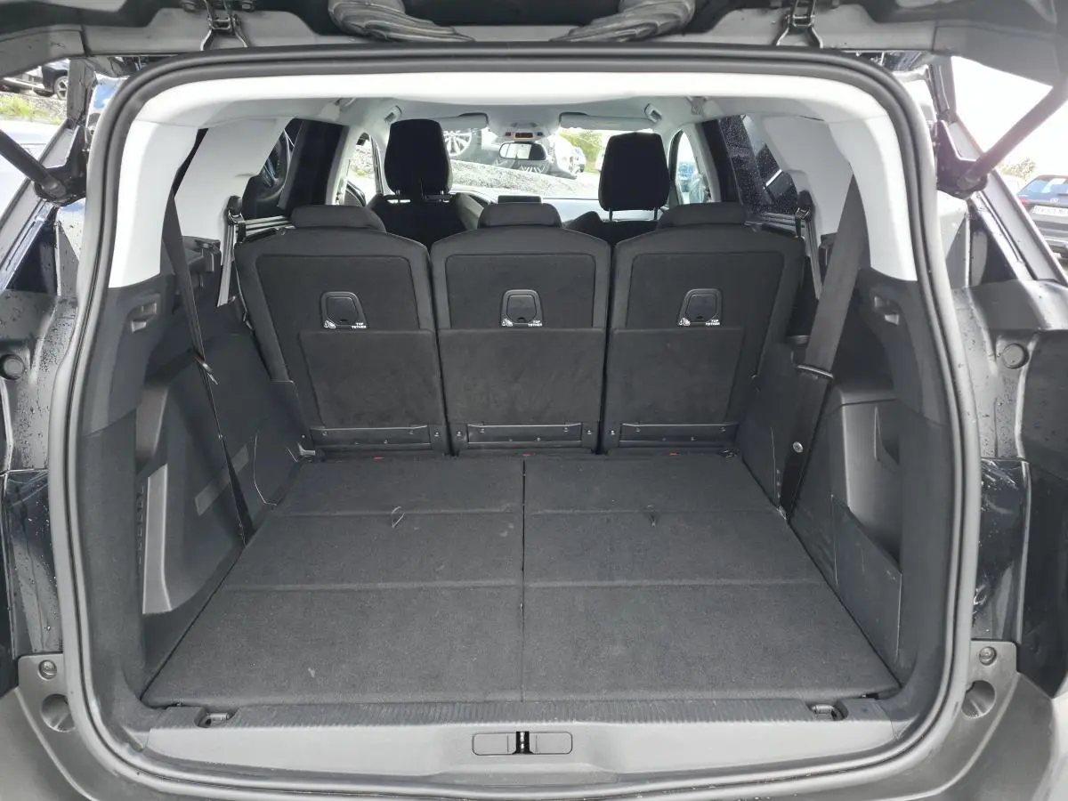 Coffre ouvert d'un Peugeot 5008 noir 2021, vue arrière montrant les sièges arrière relevés et l'espace de chargement.