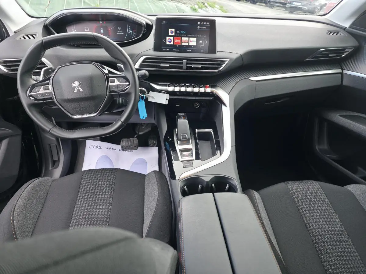 Intérieur du Peugeot 5008 2021 vu de face, volant compact, planche de bord carbone et écran tactile 10 pouces.