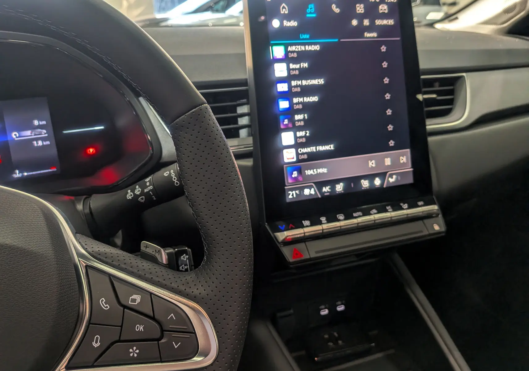 Intérieur du Renault Captur 2025, vue du volant et écran central tactile affichant les stations radio.