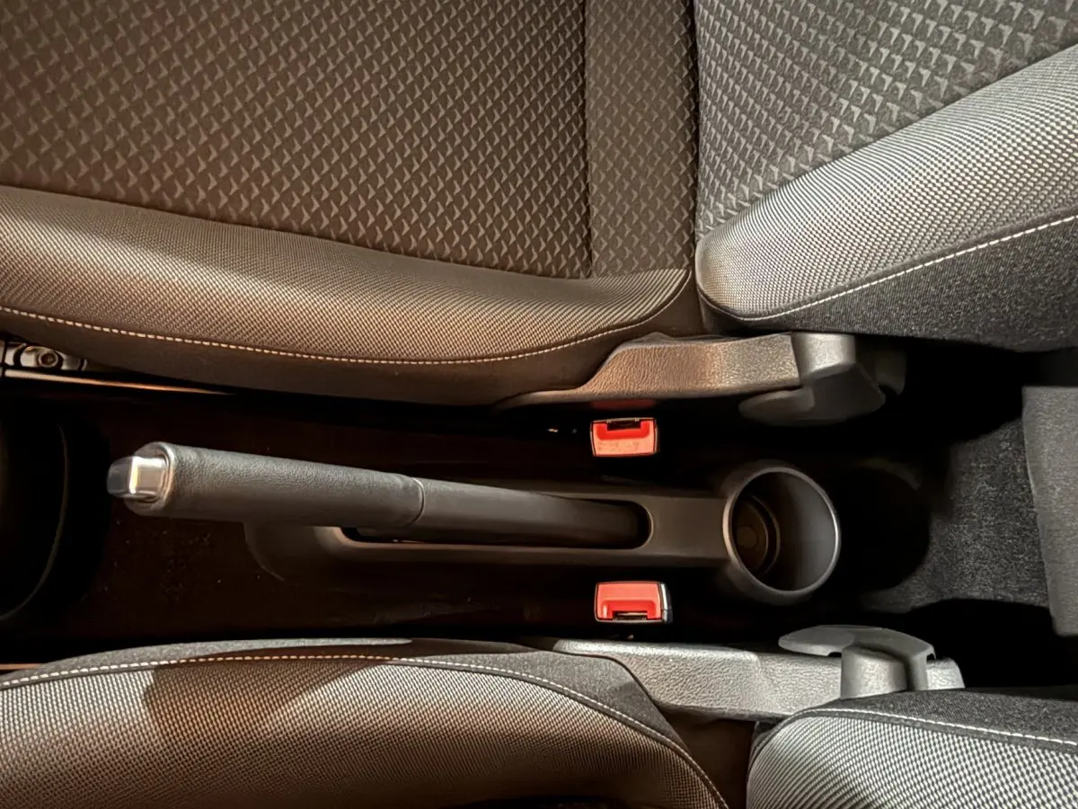 Vue rapprochée du frein à main manuel entre les sièges avant gris foncé du Volkswagen Up 1.0 65 Active.