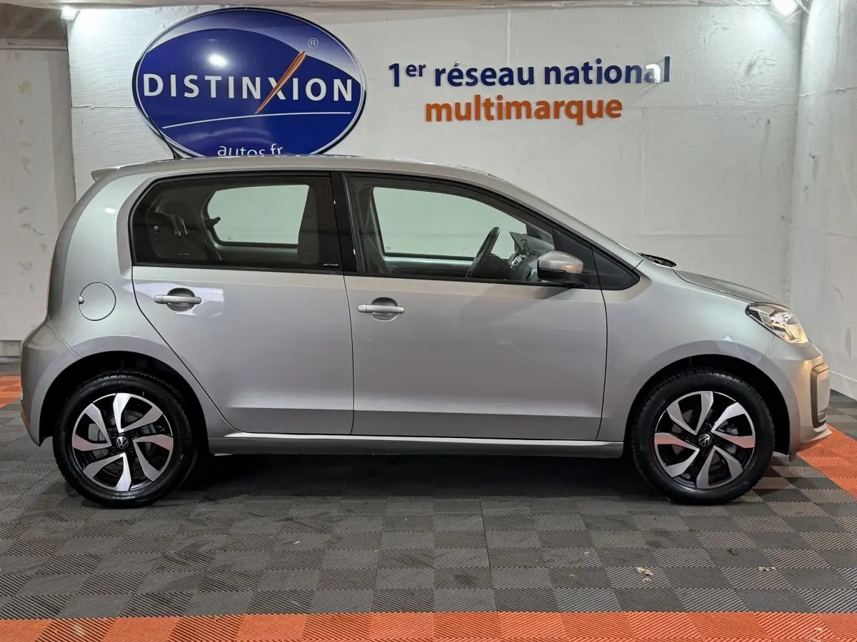 Vue de profil côté gauche d'une Volkswagen Up 1.0 65 Active gris foncé avec jantes alliage et rétroviseurs assortis.