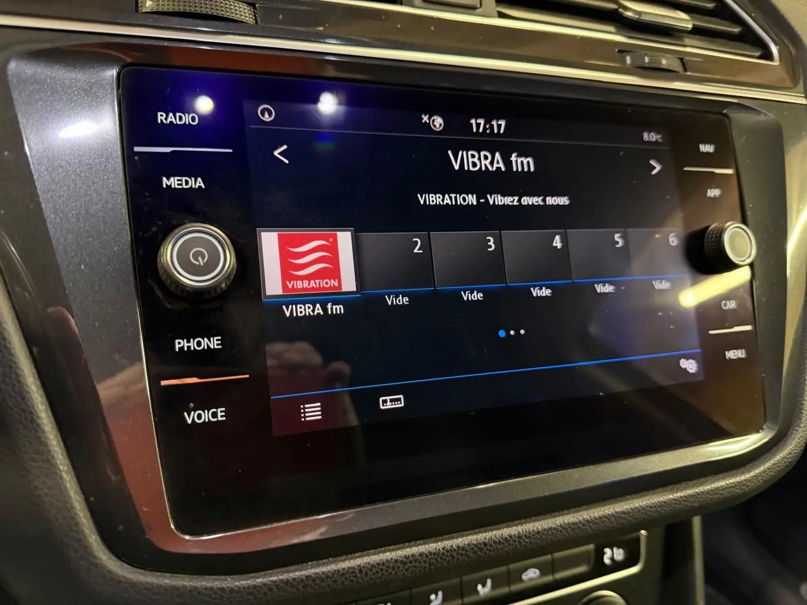 Écran tactile central du Volkswagen Tiguan 2018 affichant la radio VIBRA fm, entouré de commandes noires.