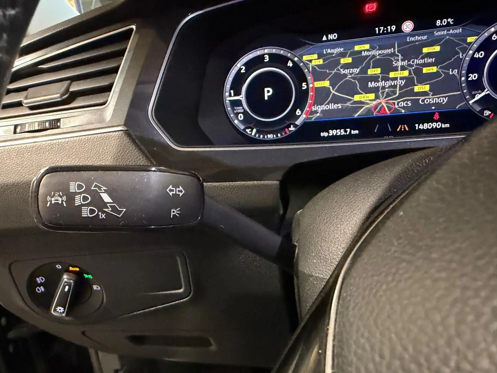 Gros plan sur le combiné d'instruments numérique et la commande des phares du Volkswagen Tiguan gris, tableau de bord moderne.