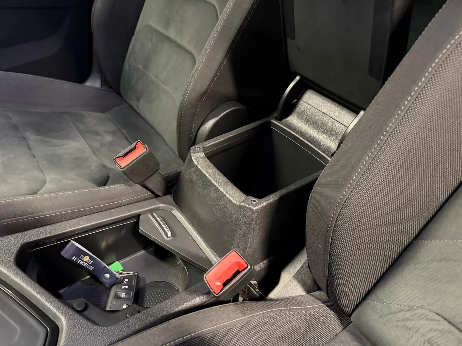 Gros plan intérieur sur la console centrale ouverte et sièges gris foncé du Volkswagen Tiguan 2.0 TDI 2018.