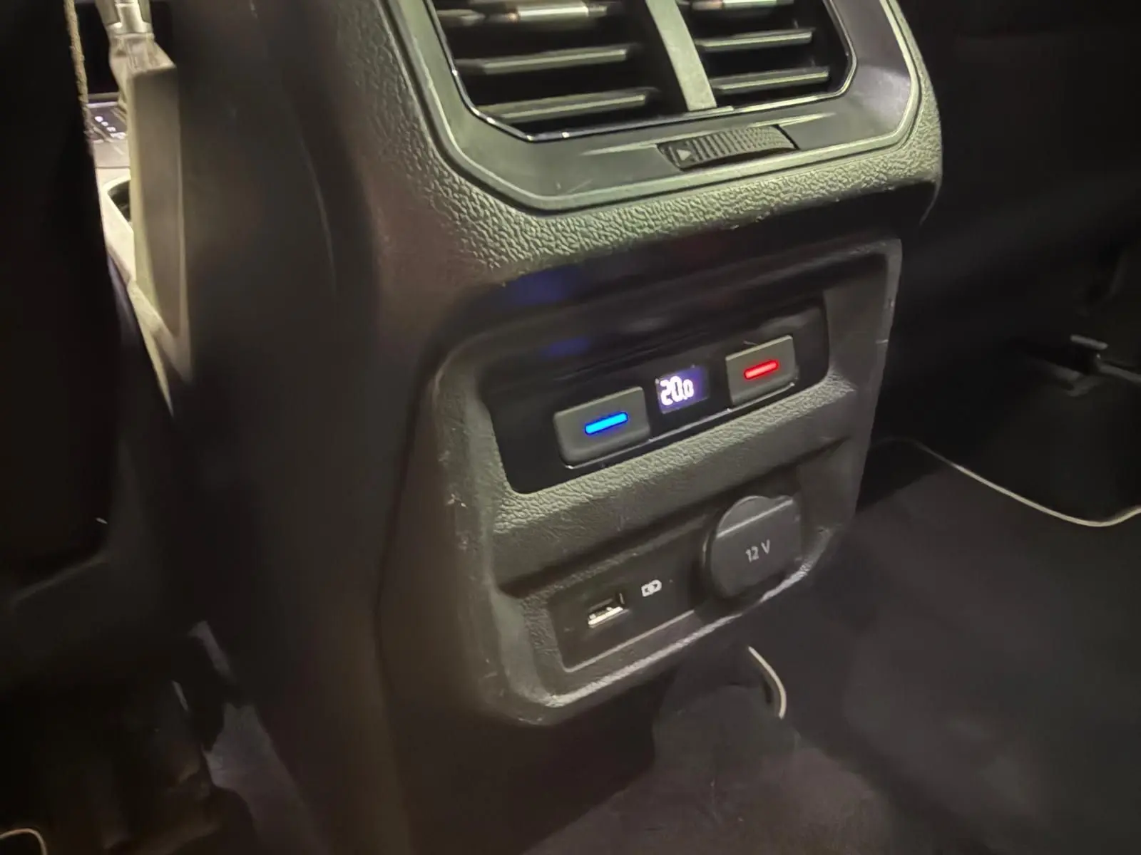 Détail de la console arrière du Volkswagen Tiguan gris montrant la climatisation et prises USB et 12V.