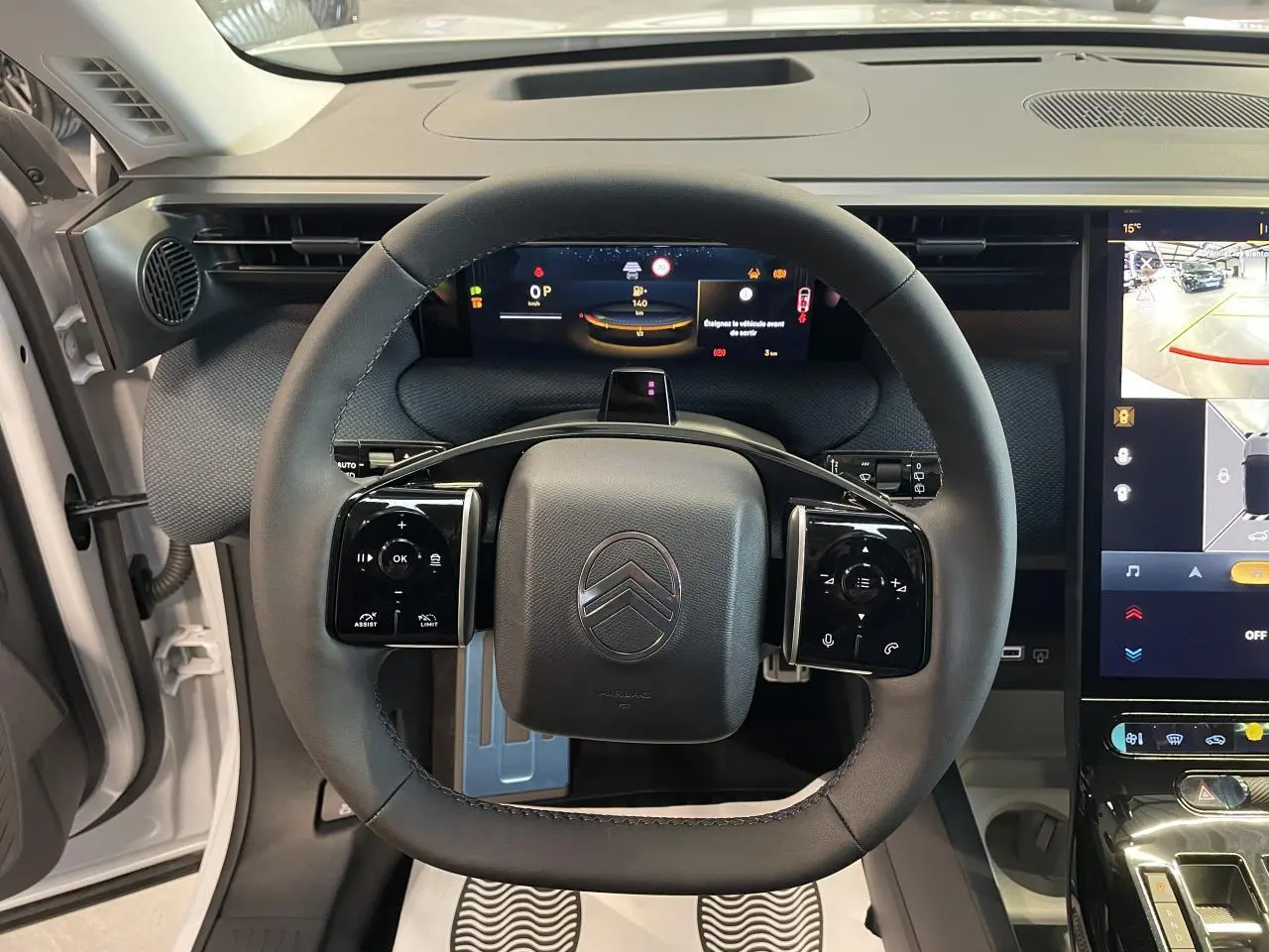 Vue frontale du volant noir du Citroën C5 Aircross 2026 blanc, avec tableau de bord numérique et écran tactile central.