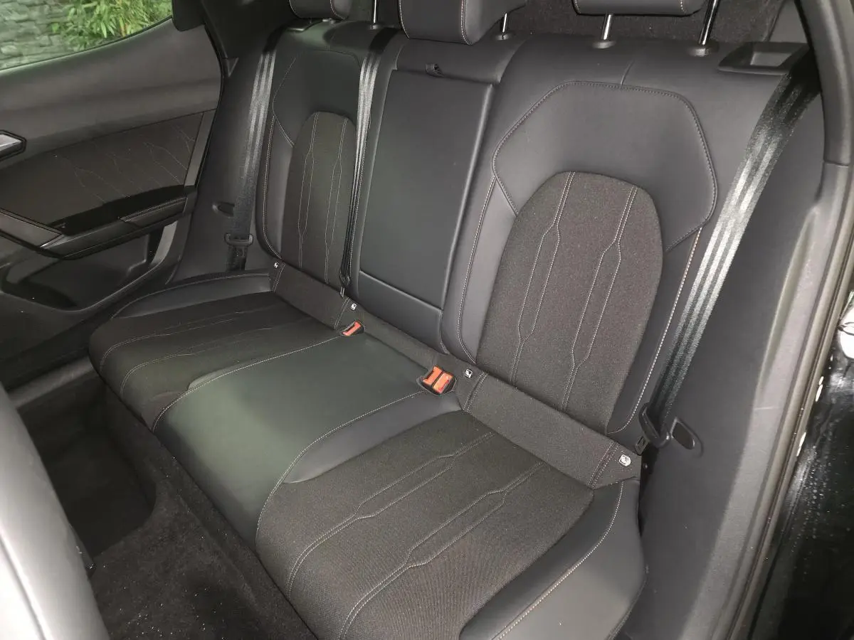 Vue intérieure sur la banquette arrière noire en tissu et TEP du CUPRA Formentor 2025, avec ceintures et surpiqûres contrastées.