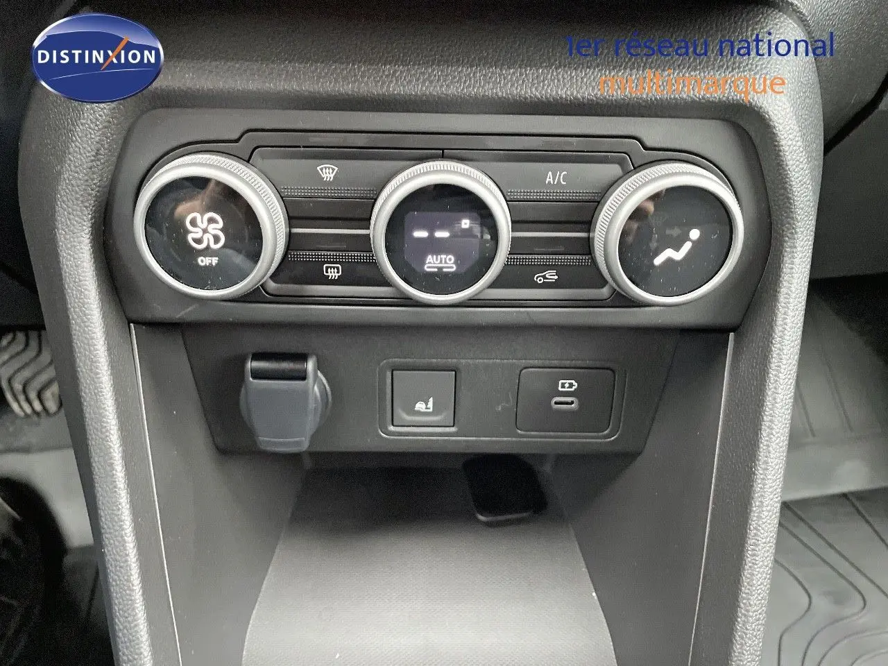 Gros plan sur la console centrale du Dacia Jogger 2024, montrant les commandes de climatisation et prises USB.