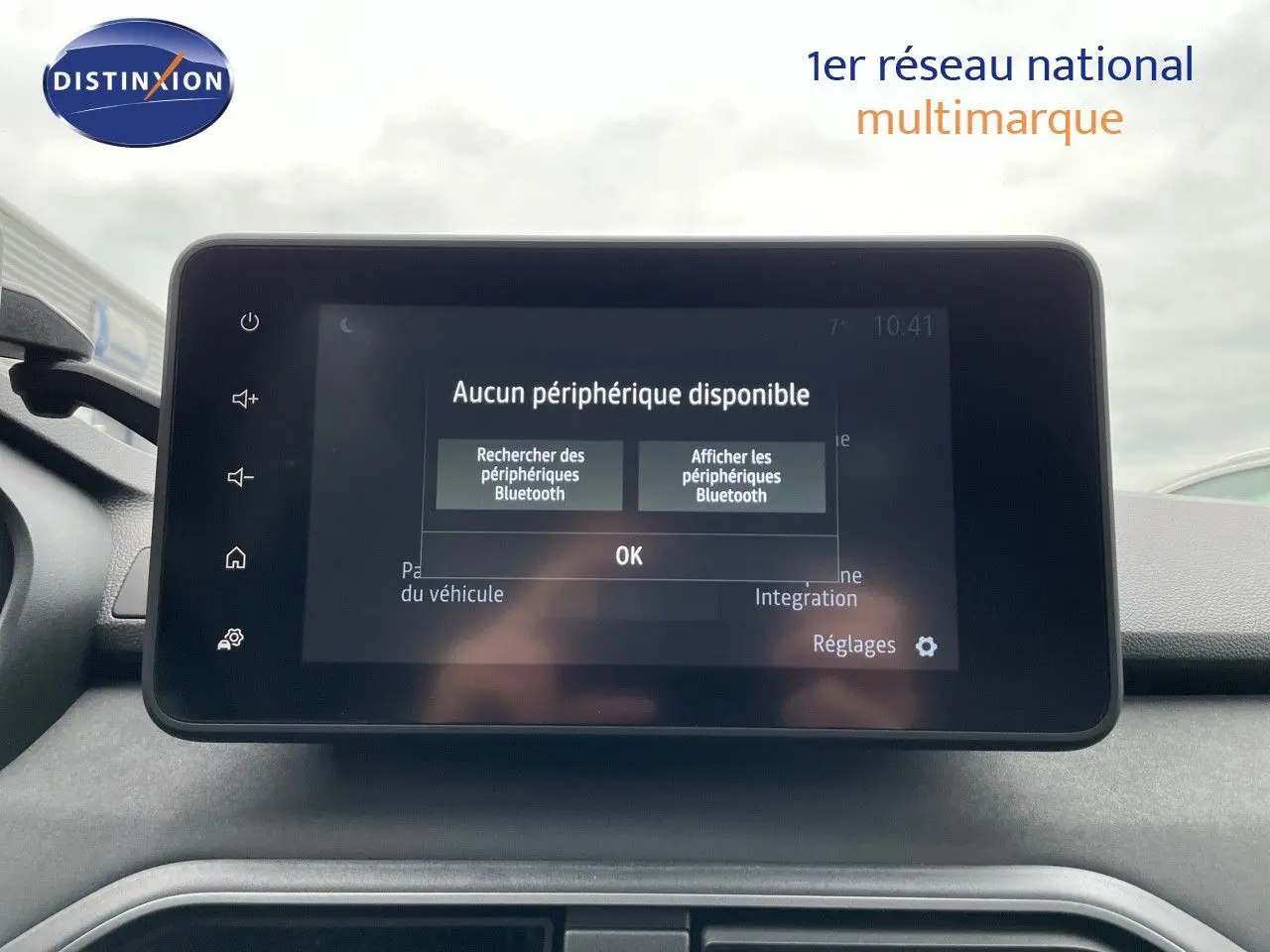 Vue intérieure centrée sur l'écran tactile du tableau de bord du Dacia Jogger 2024, affichant un message Bluetooth.
