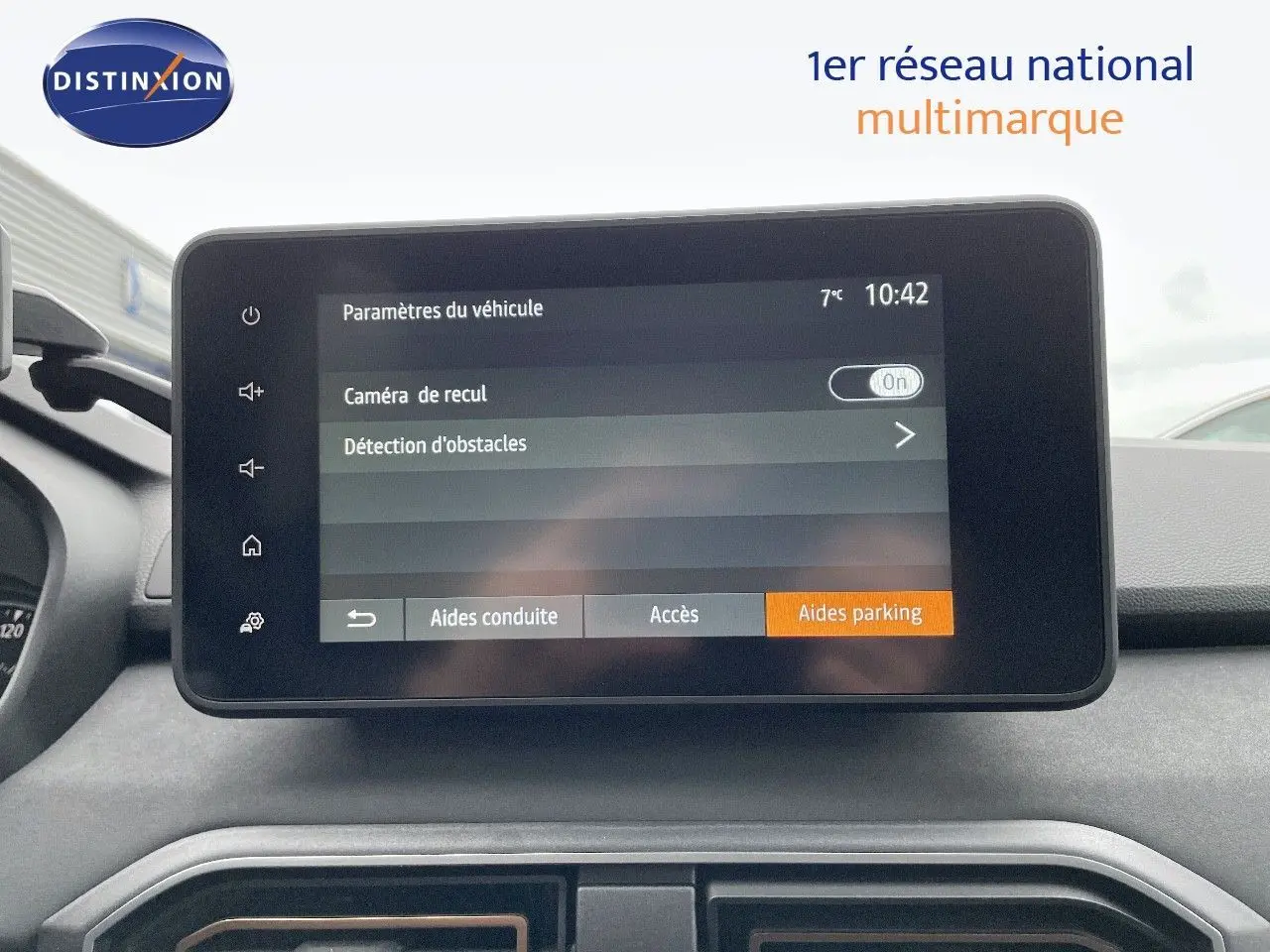 Vue intérieure centrée sur l'écran tactile du tableau de bord du Dacia Jogger noir nacré, affichant les aides au parking.