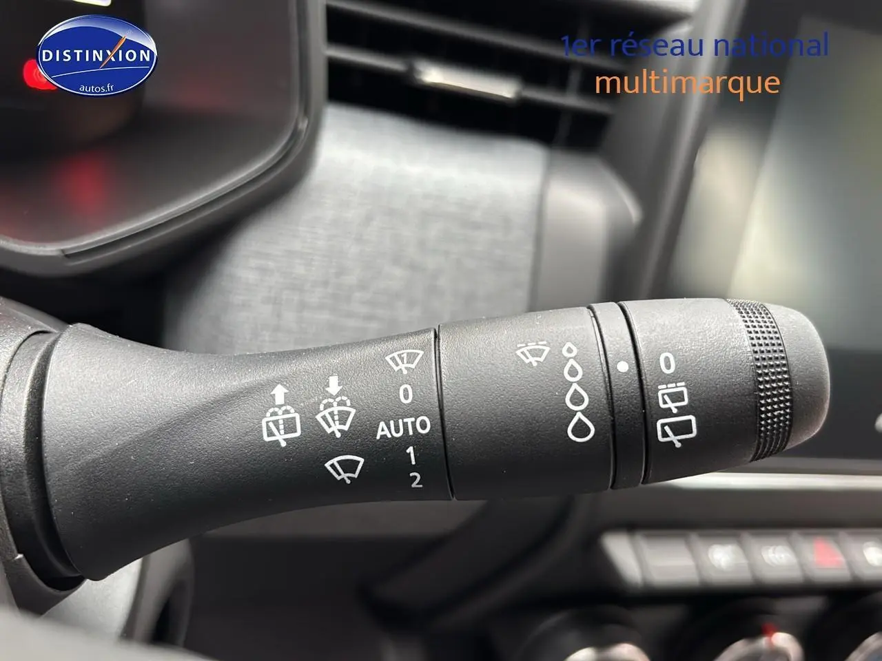 Gros plan sur la commande d'essuie-glace intérieure de la Renault Clio V noire, montrant les réglages automatiques et manuels