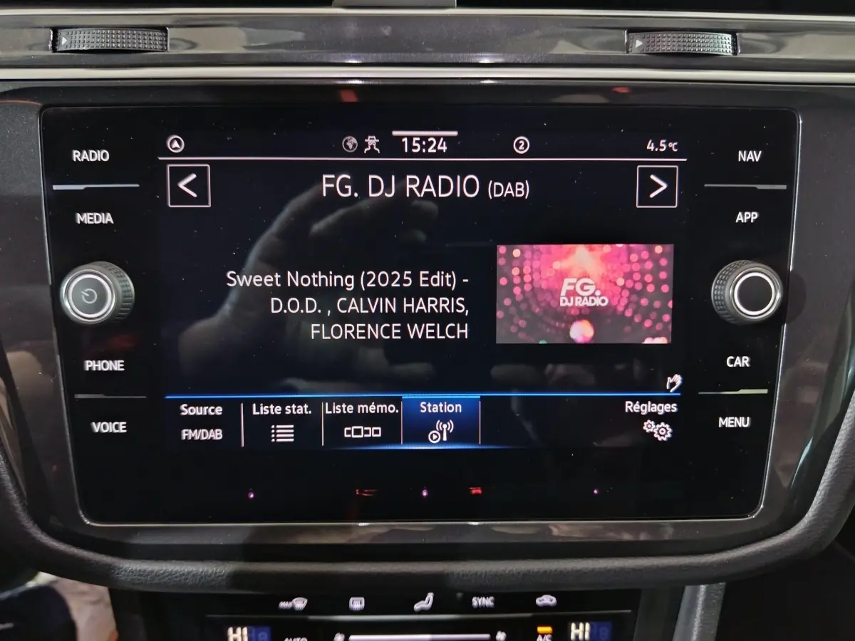 Écran tactile central du Volkswagen Tiguan 1.5 TSI bleu, affichant la radio FG DJ Radio en intérieur.