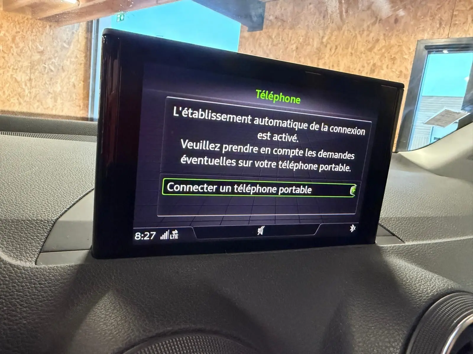 Écran multifonction affichant la connexion Bluetooth dans l'habitacle d'une Audi Q2 gris, vue de face rapprochée.