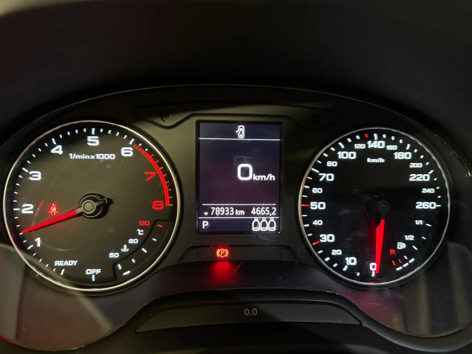 Vue rapprochée du tableau de bord de l'Audi Q2 gris, affichant compte-tours, vitesse à 0 km/h et kilométrage.