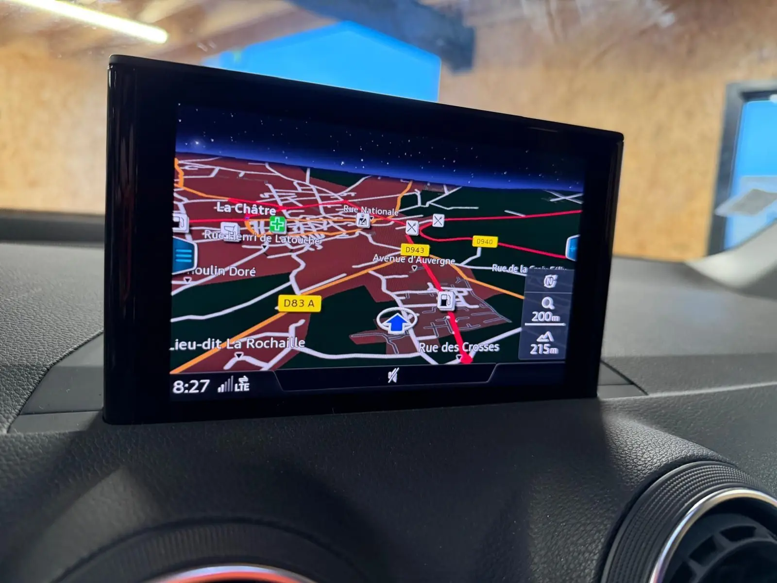 Écran GPS couleur intégré au tableau de bord de l'Audi Q2 gris, vue intérieure centrée sur la navigation.