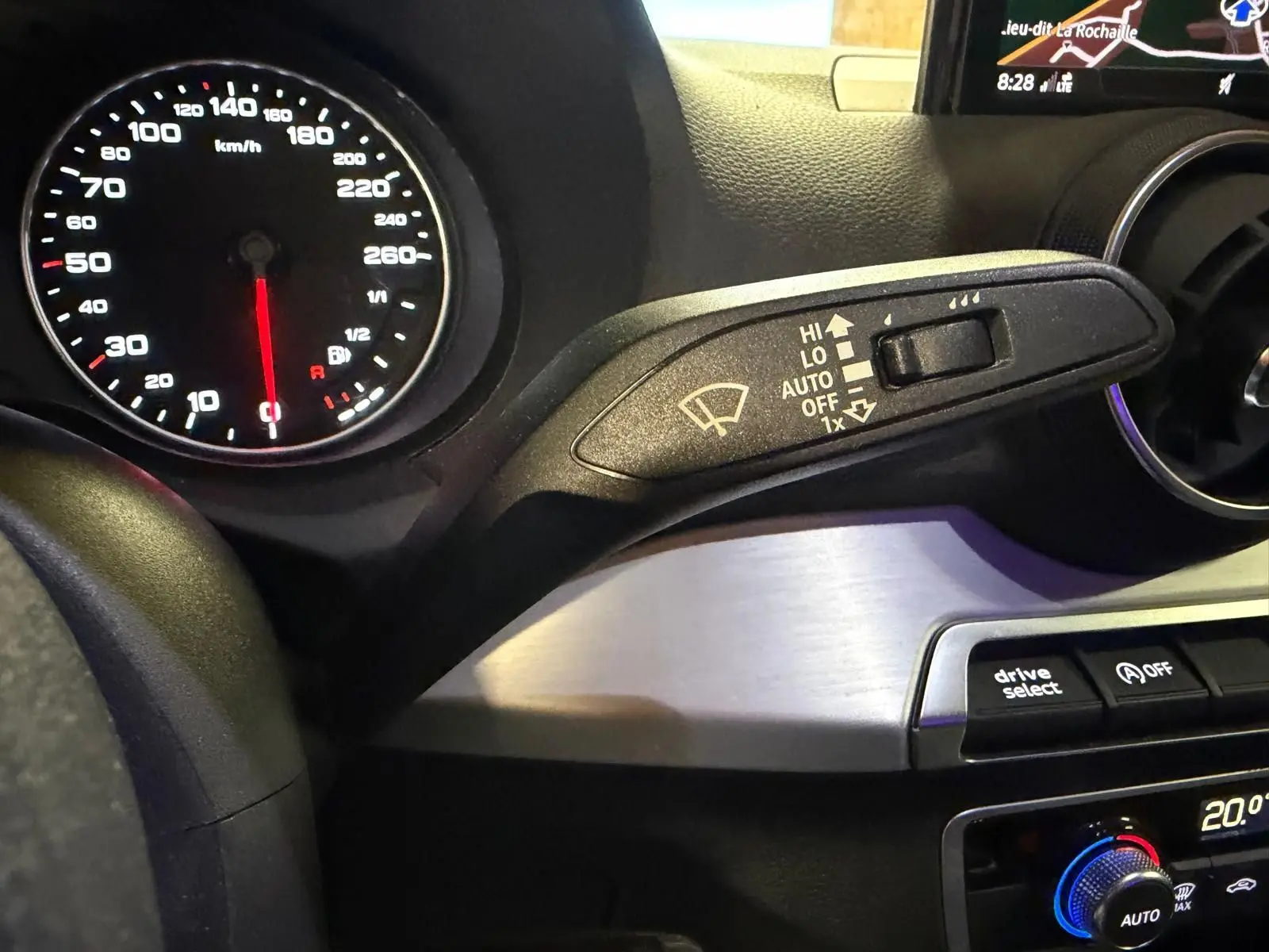 Détail intérieur du tableau de bord gris de l'Audi Q2 2018, avec compteur vitesse et commande essuie-glace.