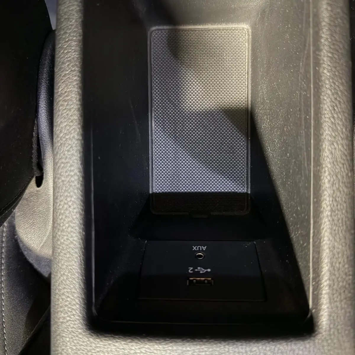 Vue rapprochée de la console centrale noire de l'Audi Q2 2018 avec prise USB et entrée AUX intégrées.