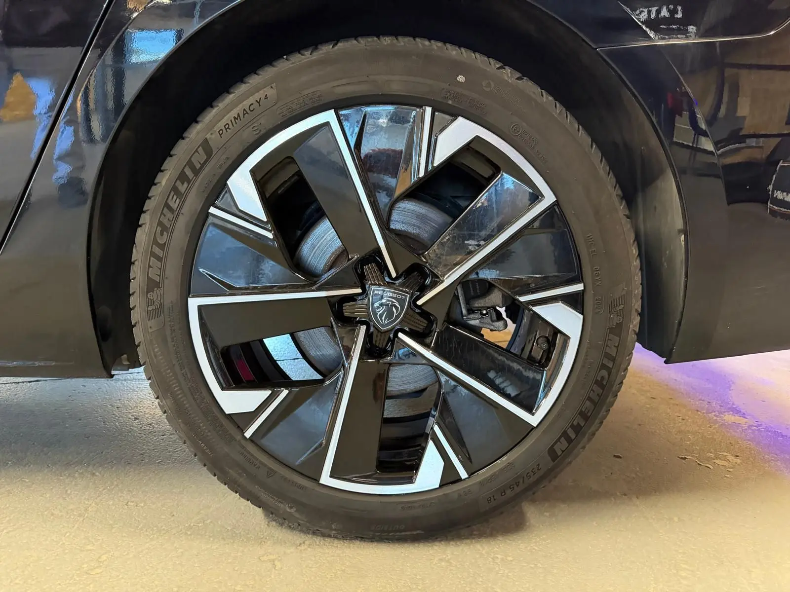 Gros plan sur la jante alliage 18'' bi-ton diamantée noire et argentée du côté arrière droit d'une Peugeot 508 SW noire.