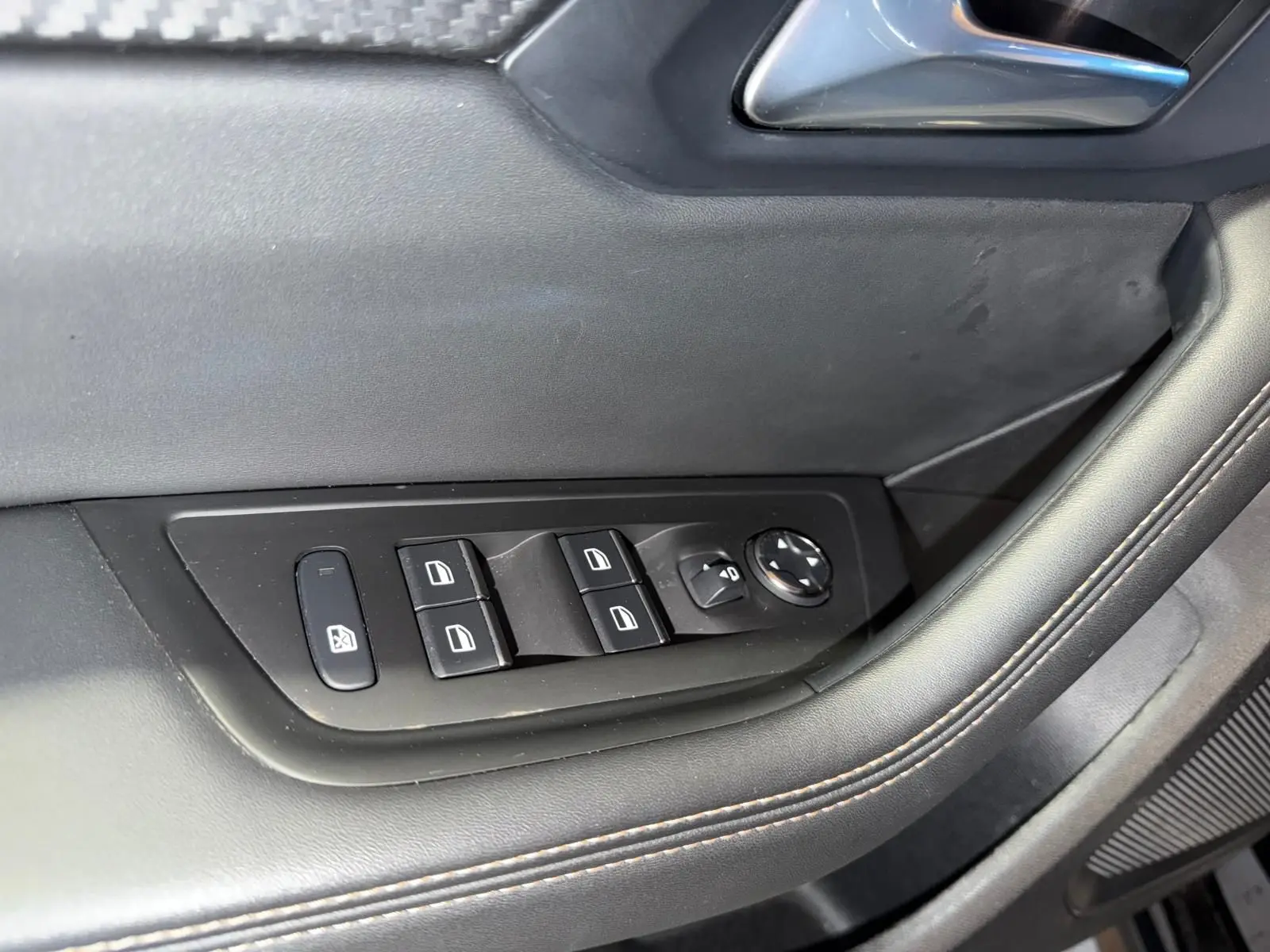 Détail des commandes de lève-vitres et rétroviseurs sur la porte côté conducteur d’un Peugeot 508 SW noir.